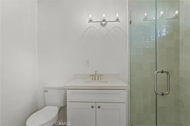 a bathroom with a granite countertop sink a toilet and shower