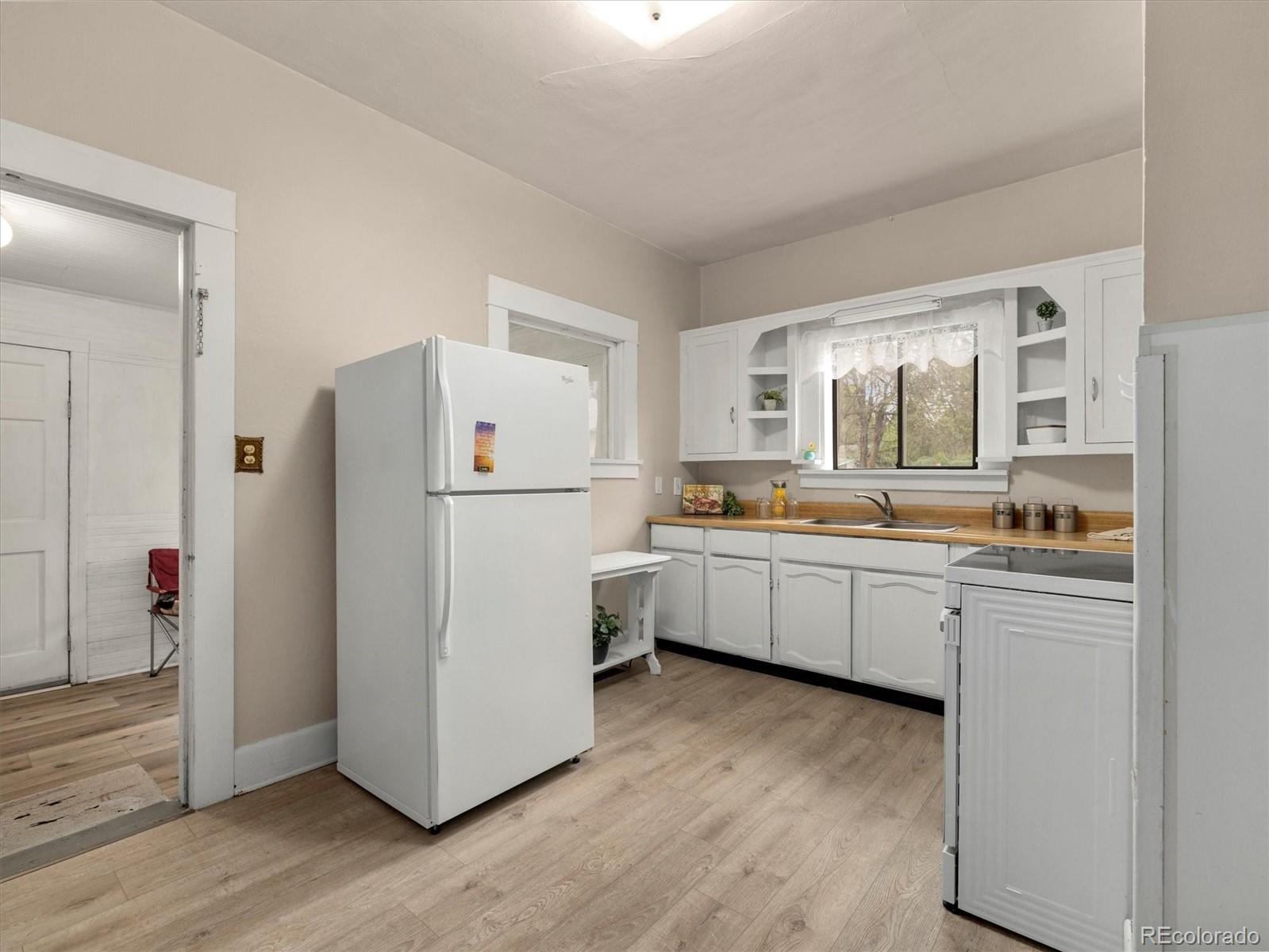 708 7th Street Fowler, CO 81039 - Photo 13 of 17 a kitchen with white cabinets and white appliances