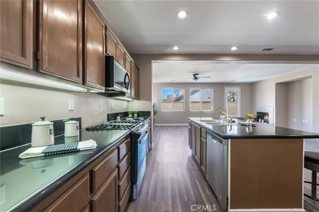a kitchen with stainless steel appliances granite countertop a sink stove and cabinets