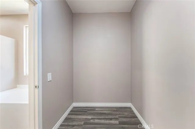 a room with a white bed and dresser