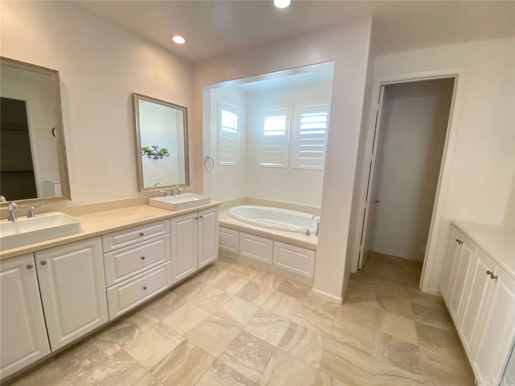 149 Allium Irvine, CA 92618 - Photo 22 of 26 a spacious bathroom with a double vanity sink a mirror and a bathtub