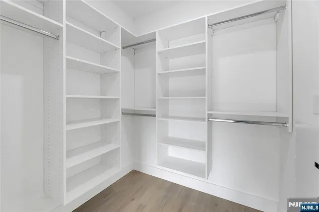 a view of walk in closet with empty racks