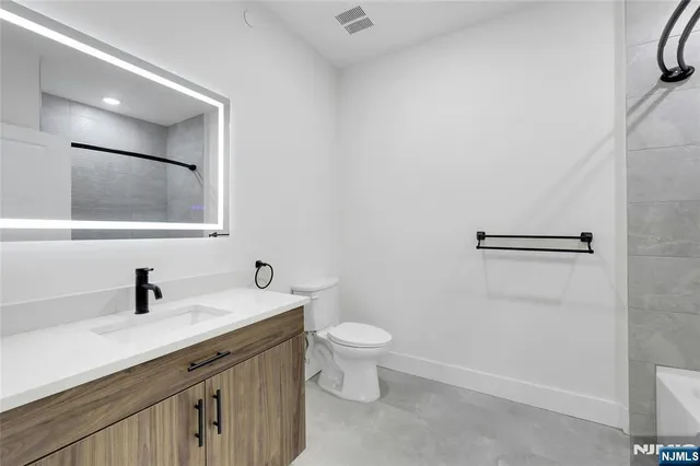 a bathroom with a double vanity sink toilet and a mirror
