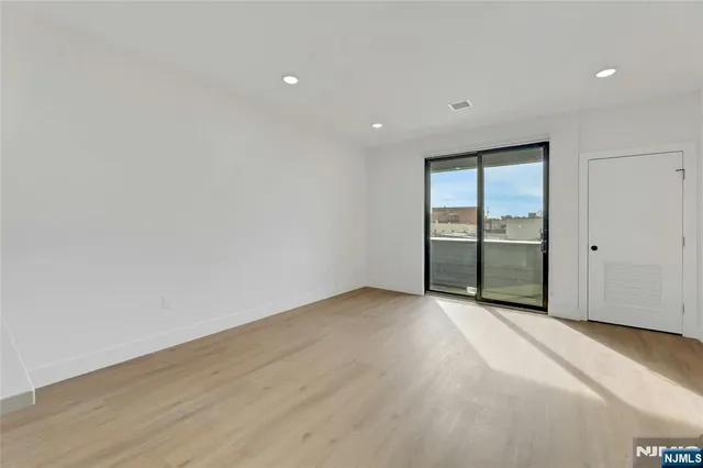 an empty room with wooden floor and sliding door
