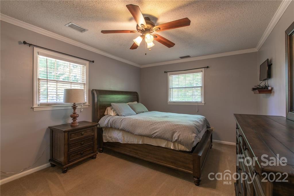 209 Fallingtree Lane Monroe, NC 28112 - Photo 15 of 22 a bedroom with a bed next to a window and a chandelier