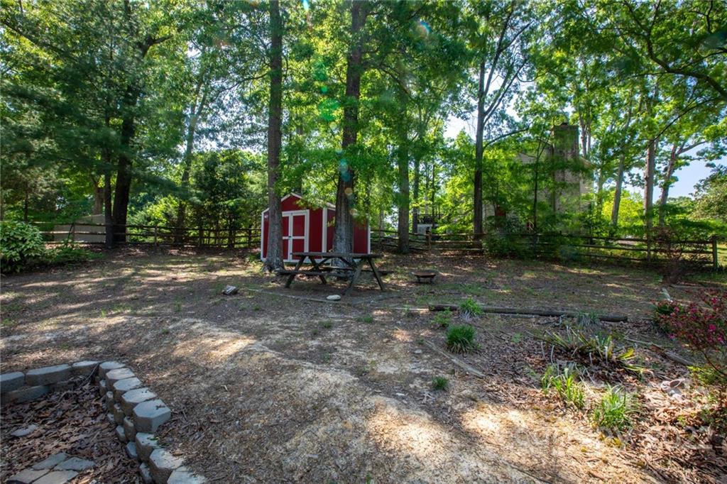 209 Fallingtree Lane Monroe, NC 28112 - Photo 19 of 22 a view of a fire pit with large trees