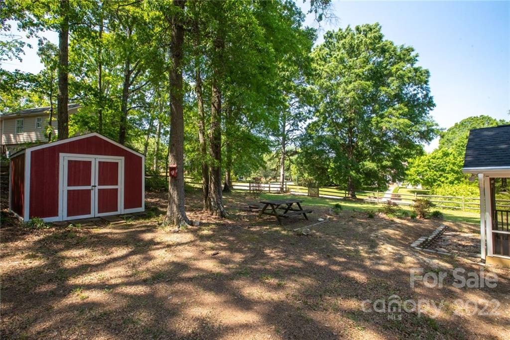 209 Fallingtree Lane Monroe, NC 28112 - Photo 21 of 22 a view of a yard with large trees and a barn in it