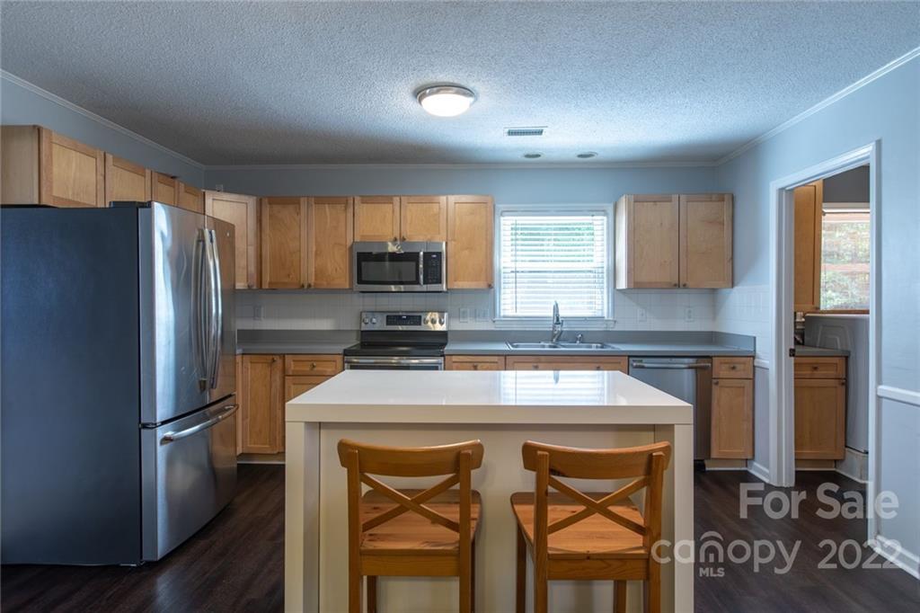 209 Fallingtree Lane Monroe, NC 28112 - Photo 8 of 22 a kitchen with a refrigerator a microwave a sink and cabinets