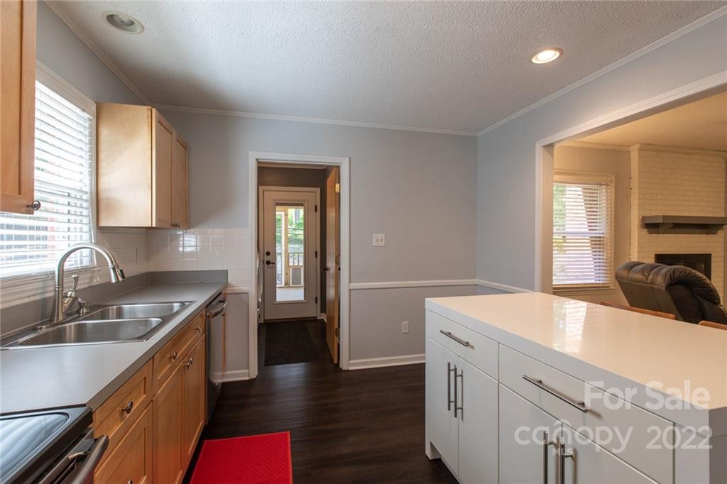 209 Fallingtree Lane Monroe, NC 28112 - Photo 10 of 22 a kitchen with a sink dishwasher a stove and white cabinets with wooden floor