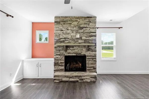 a living room with a fireplace and wooden floor