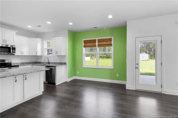 a kitchen with granite countertop wooden floors and wide window