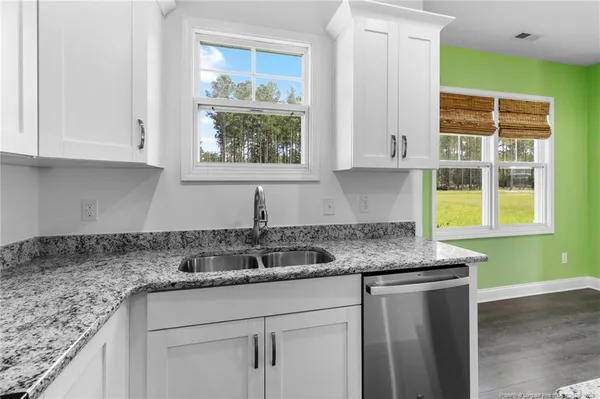 a kitchen with stainless steel appliances granite countertop a sink and a window