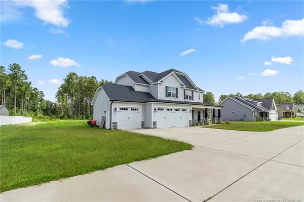 a view of a house with a big yard and large trees