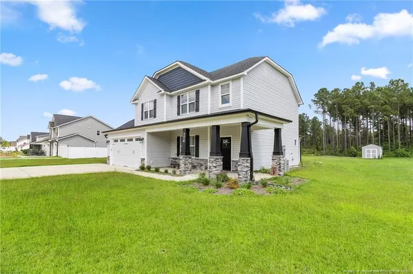 a view of a house with a yard and sitting area