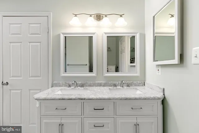 a bathroom with a granite countertop sink and a mirror