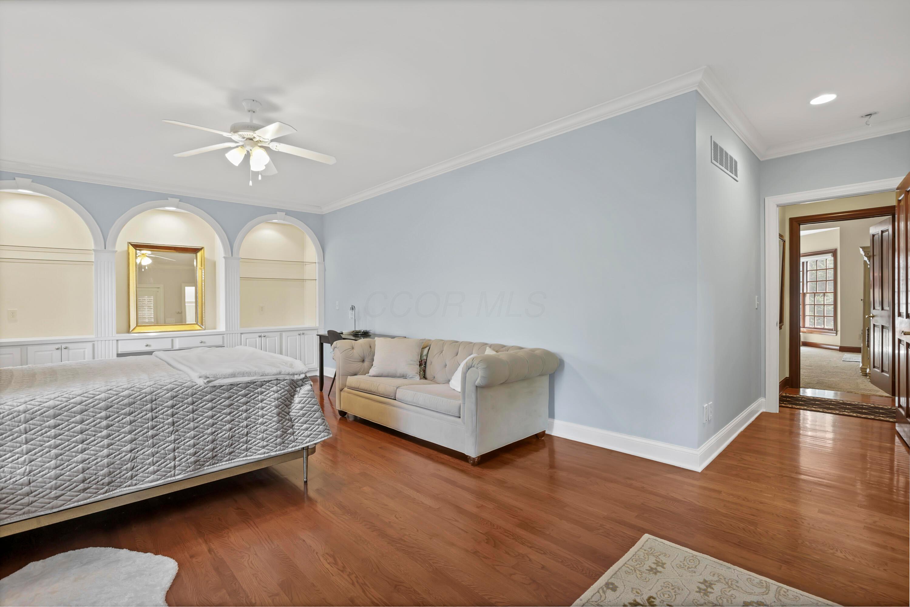 3575 State Rte 37 West Delaware, OH 43015 - Photo 62 of 106 Hardwood flooring extends throughout this room, featuring arched built-in shelving, crown molding, and a ceiling fan
