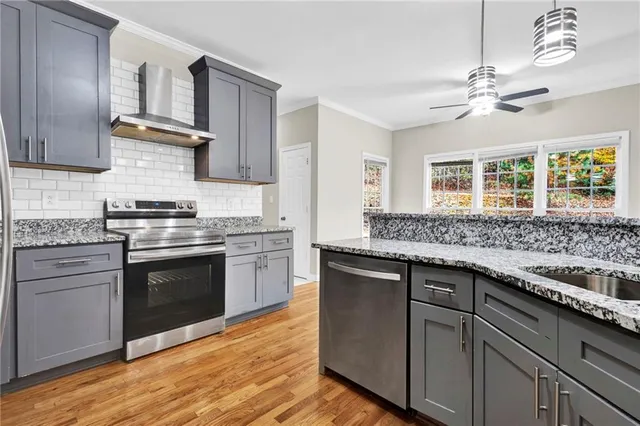 a kitchen with cabinets wooden floor and a stove top oven