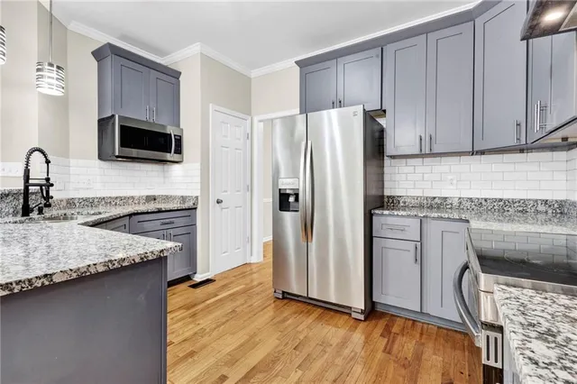 a kitchen with stainless steel appliances granite countertop a refrigerator and a stove top oven