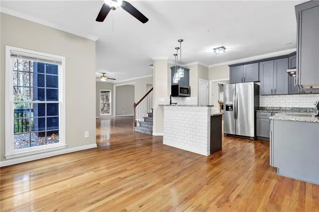 a view of kitchen with refrigerator microwave and wooden floor