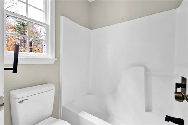 a white toilet sitting next to a bath tub