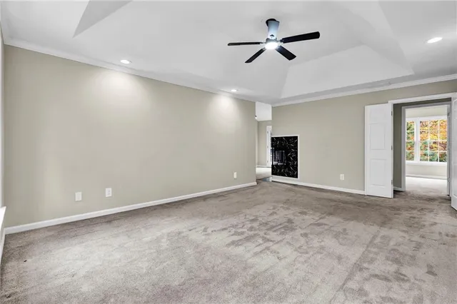 an empty room with ceiling fan and window