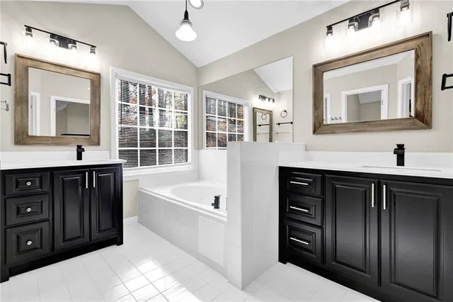 a bathroom with a tub sink and mirror