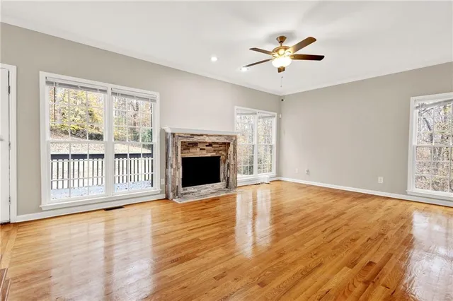 a view of empty room with wooden floor and fireplace