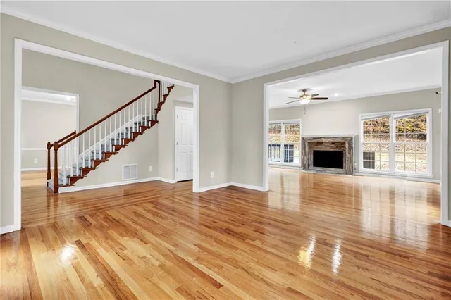 a view of empty room with wooden floor and fireplace