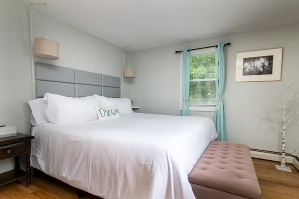 a bedroom with a bed and wooden floor