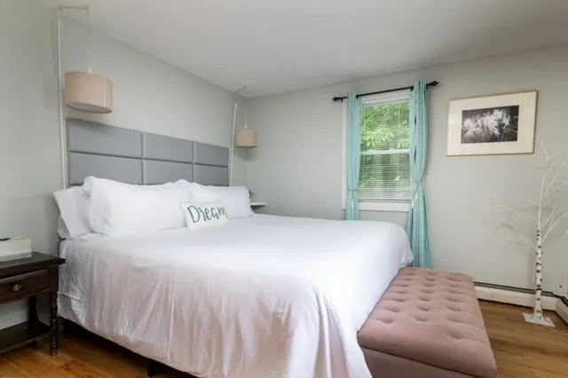 a bedroom with a bed and wooden floor