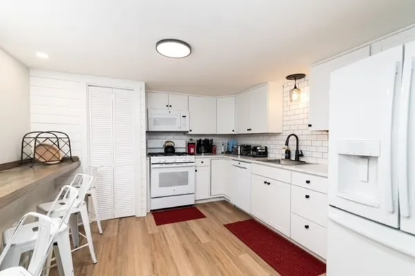 a kitchen with granite countertop white cabinets and stainless steel appliances