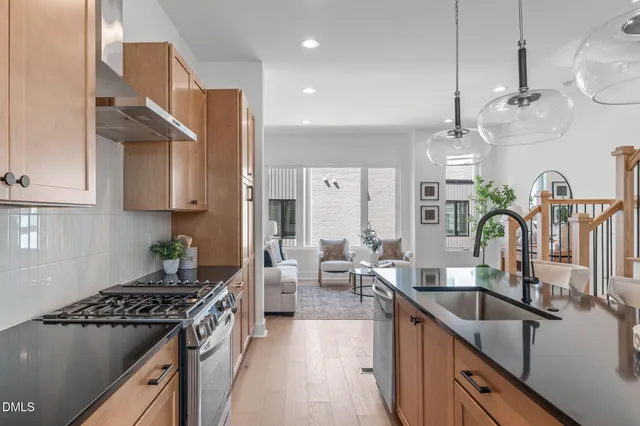 a kitchen with stainless steel appliances a sink a stove top oven a counter space and cabinets