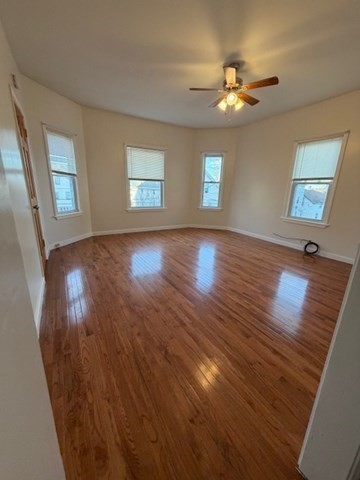 137 Tecumseh Street, Unit 2 Fall River, MA 02721 - Photo 2 of 11 a view of an empty room with wooden floor and a window