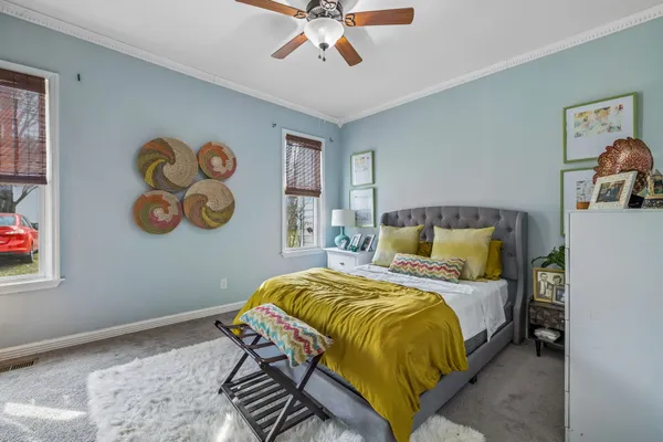 a bedroom with a bed and painting on the wall