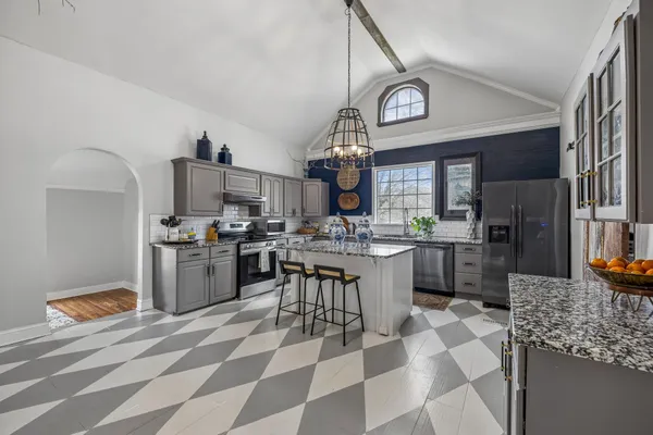 a kitchen with stainless steel appliances a stove a sink cabinets and a counter top space