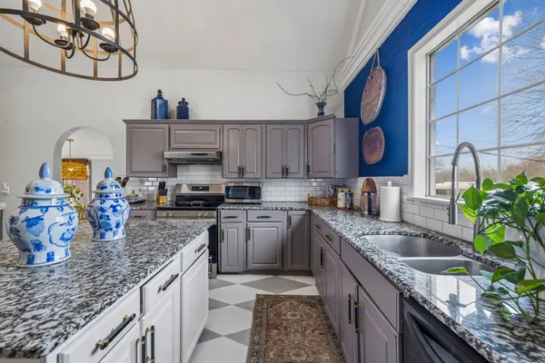 a kitchen with stainless steel appliances granite countertop a sink stove and cabinets