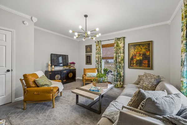 a living room with furniture a chandelier and a flat screen tv