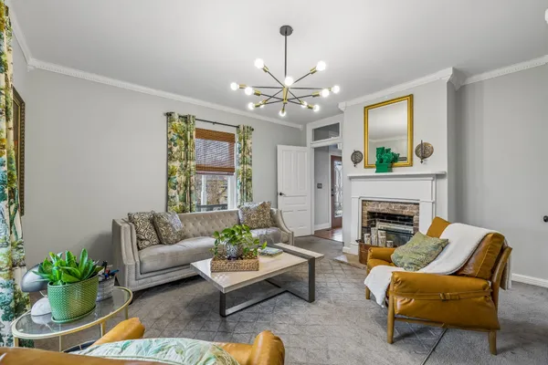 a living room with furniture a chandelier and a fireplace