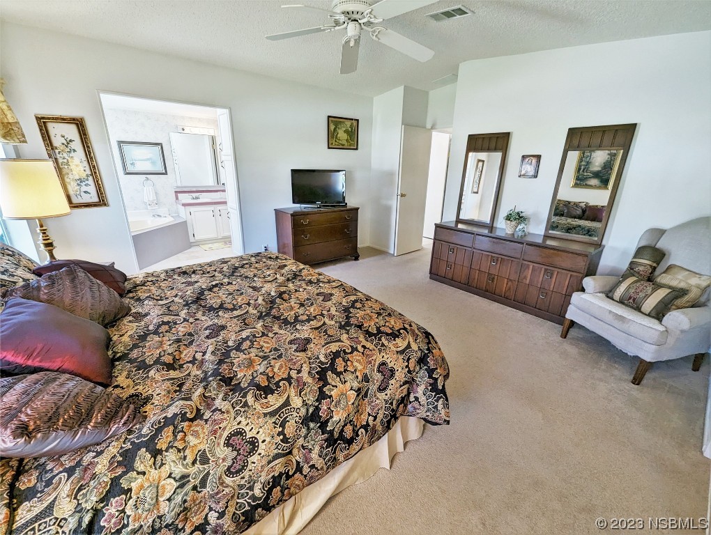 708 Navigators Way Edgewater, FL 32141 - Photo 17 of 26 a spacious bedroom with a bed a couch and dresser