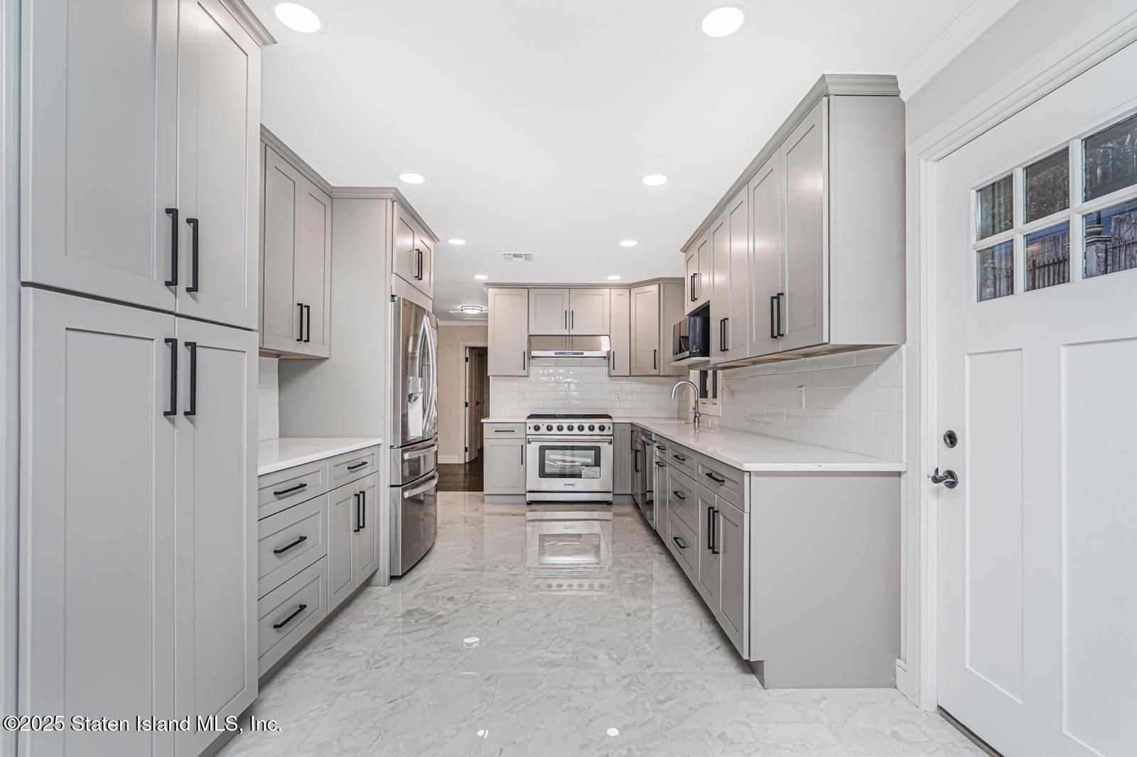 113 Longview Road Staten Island, NY 10304 - Photo 11 of 35 a kitchen with stainless steel appliances a sink and a refrigerator