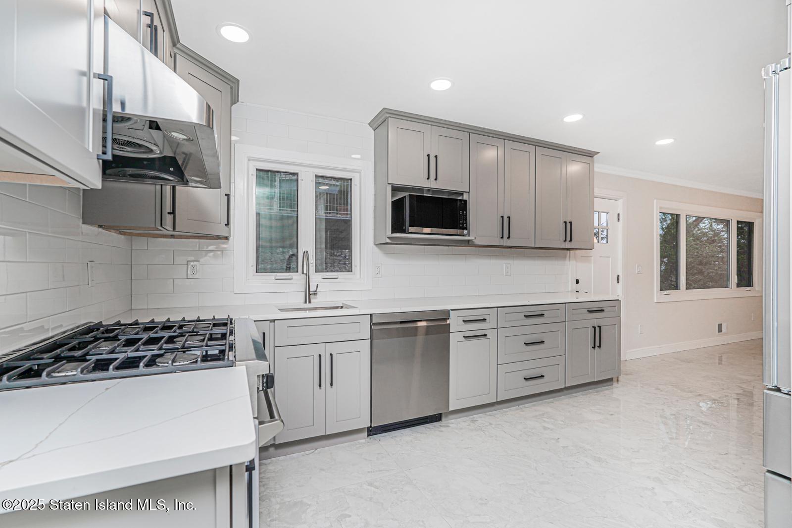 113 Longview Road Staten Island, NY 10304 - Photo 12 of 35 a kitchen with stainless steel appliances a stove a sink and a microwave