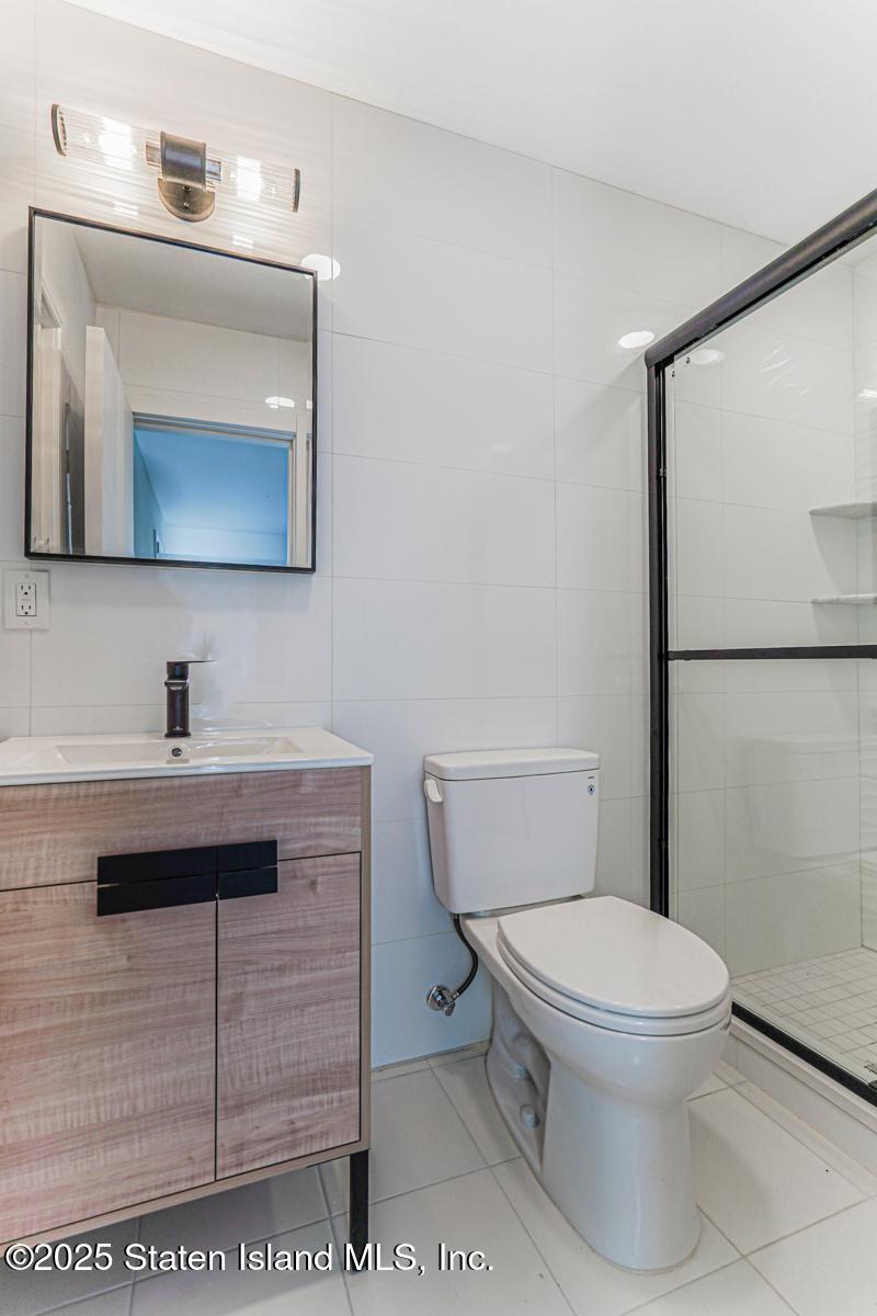 113 Longview Road Staten Island, NY 10304 - Photo 17 of 35 a bathroom with a toilet a sink and mirror