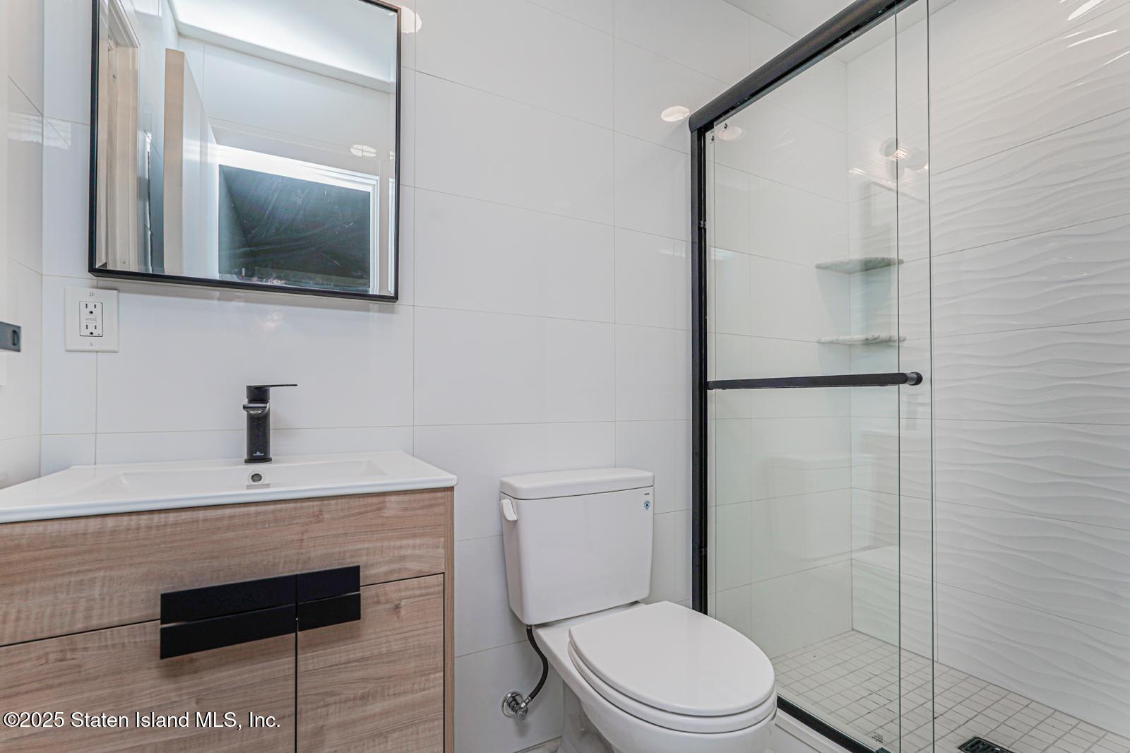 113 Longview Road Staten Island, NY 10304 - Photo 18 of 35 a bathroom with a toilet a sink and mirror