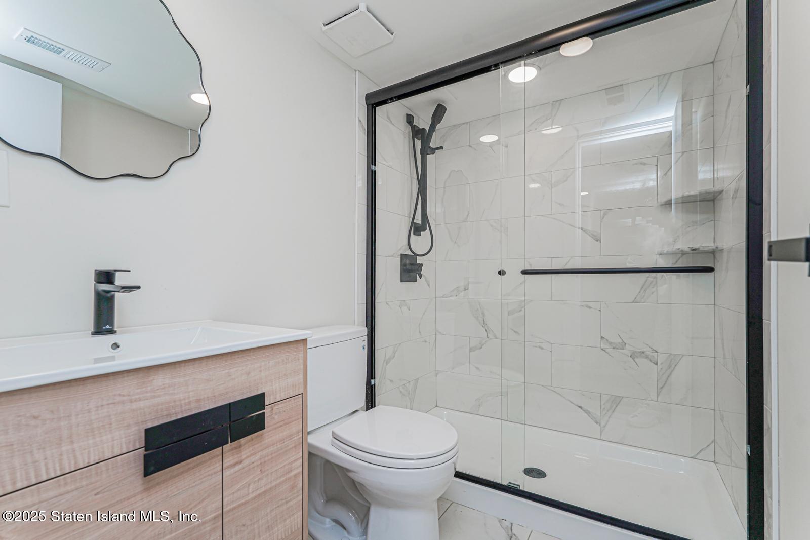 113 Longview Road Staten Island, NY 10304 - Photo 19 of 35 a bathroom with a shower a toilet and a sink