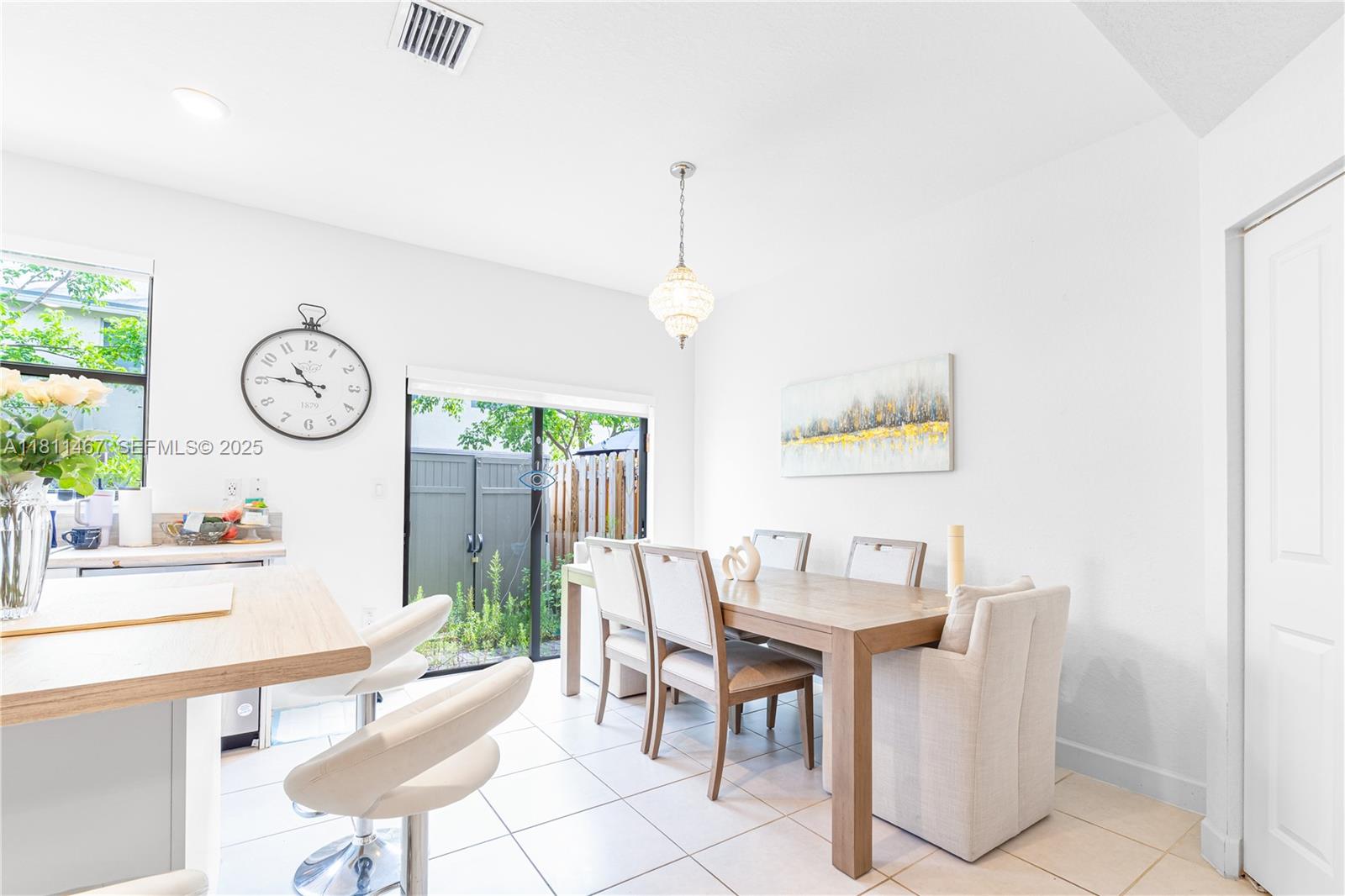 817 Northeast 211th Street Miami, FL 33179 - Photo 11 of 20 a dining room with furniture a window and a clock