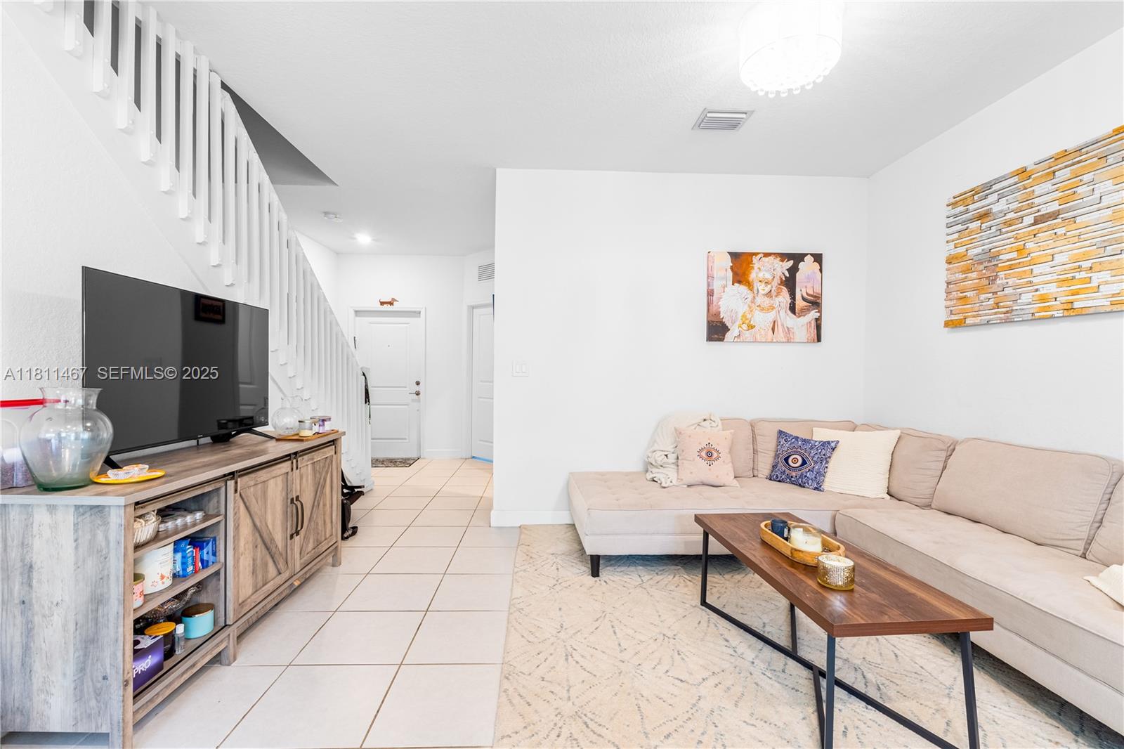 817 Northeast 211th Street Miami, FL 33179 - Photo 12 of 20 a living room with furniture and a flat screen tv