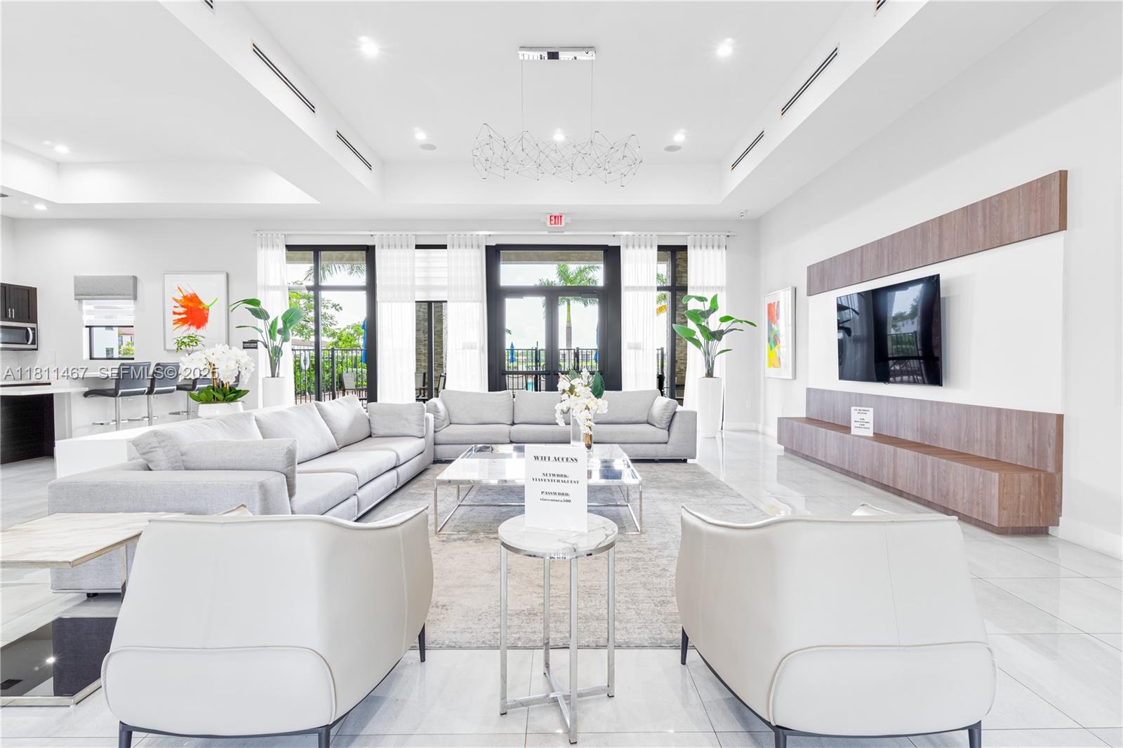 817 Northeast 211th Street Miami, FL 33179 - Photo 18 of 20 a living room with furniture a flat screen tv and a large window