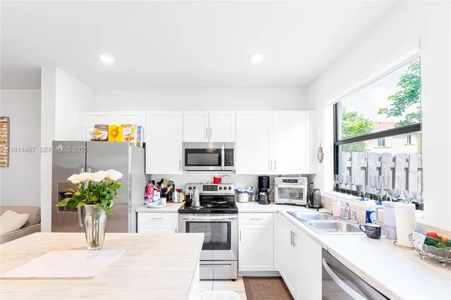 a kitchen with stainless steel appliances kitchen island granite countertop a sink cabinets and a counter top space