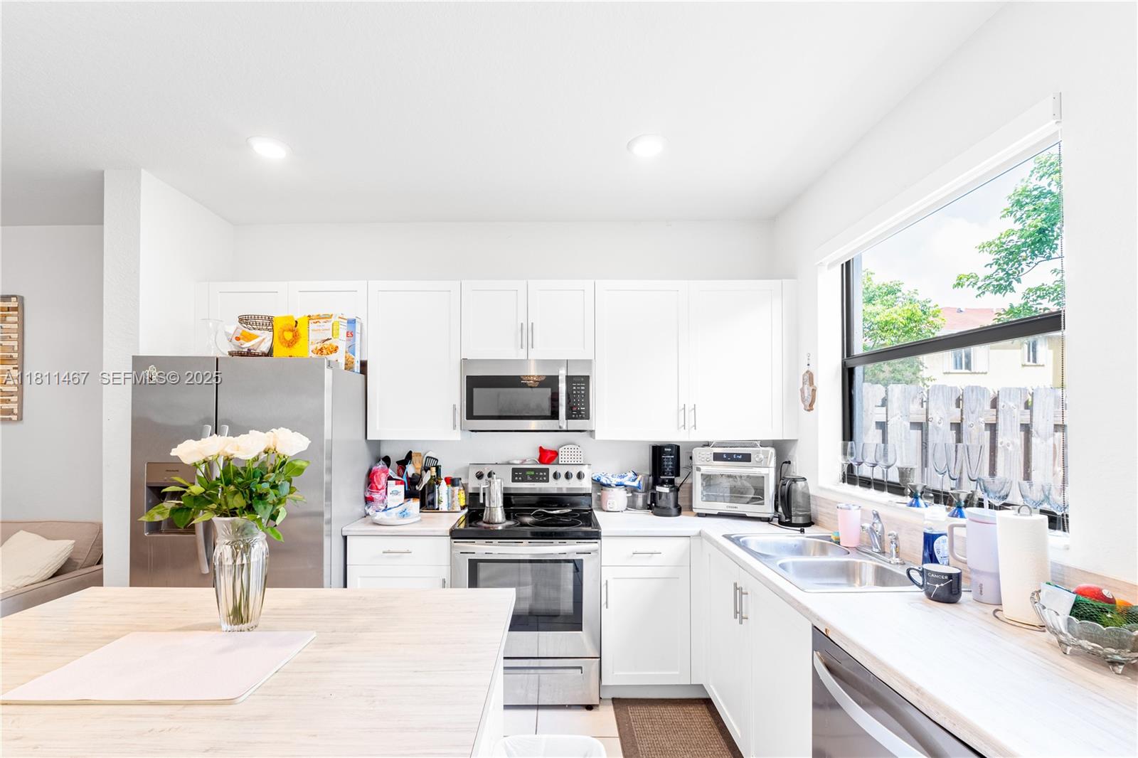 817 Northeast 211th Street Miami, FL 33179 - Photo 10 of 20 a kitchen with stainless steel appliances kitchen island granite countertop a sink cabinets and a counter top space