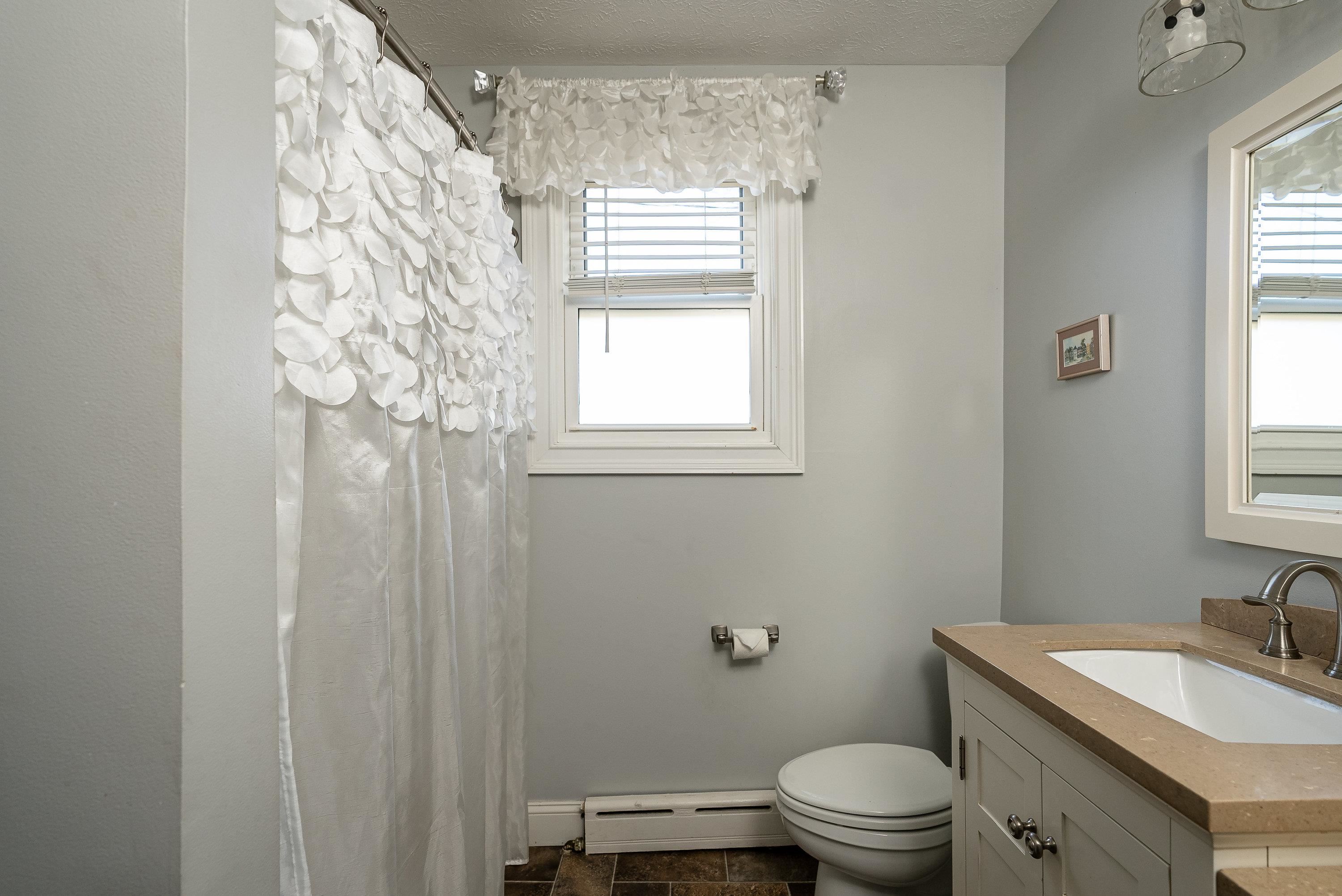 3667 Dry Hollow Road Dayton, VA 22821 - Photo 27 of 68 a bathroom with a granite countertop toilet a sink a mirror and a window